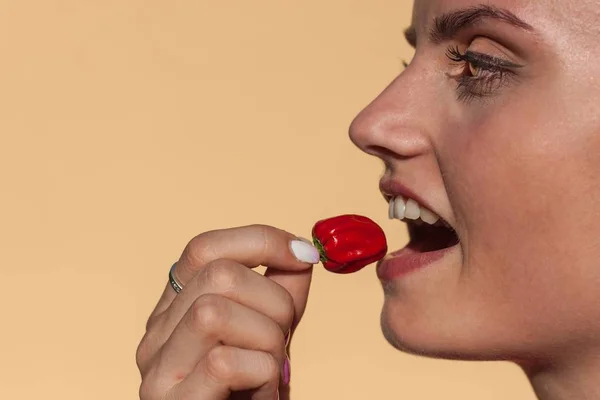 Giovane bella ragazza mangia peperoncino. Ritratto di bella donna con peperoncino. Dieta sana. Cibo piccante . — Foto Stock