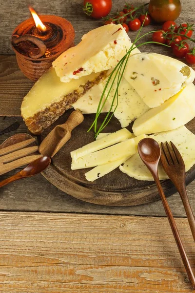 Sliced hard cheese on the kitchen board. Production of cheeses on the farm. Different types of homemade cheese. — Stock Photo, Image