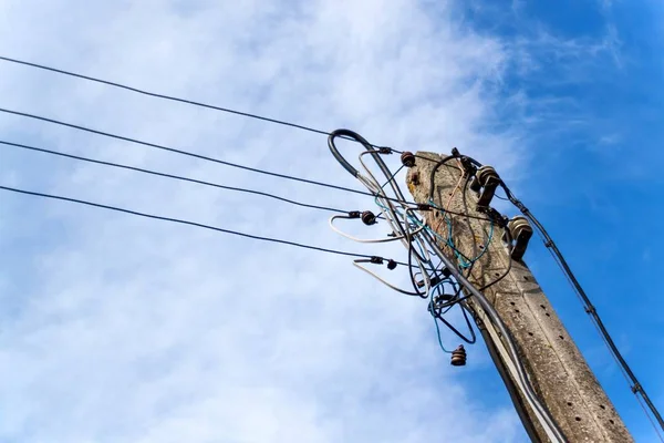 Concrete column of power line. Chaotic electrical connection. Tangle of wires. — Stock Photo, Image