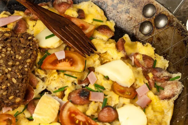 Fresh scrambled egg with ham and chilli peppers on a steel pan. A nourishing traditional breakfast. Calorie meals. — Stock Photo, Image