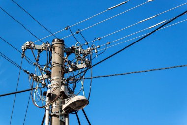 Yardımcı programı'nı kutup veya elektrik direğinden. Sütun ile elektrik güç bağlantısını kesin. Mavi açık gökyüzü. Üç fazlı güç hat bağlantısı.