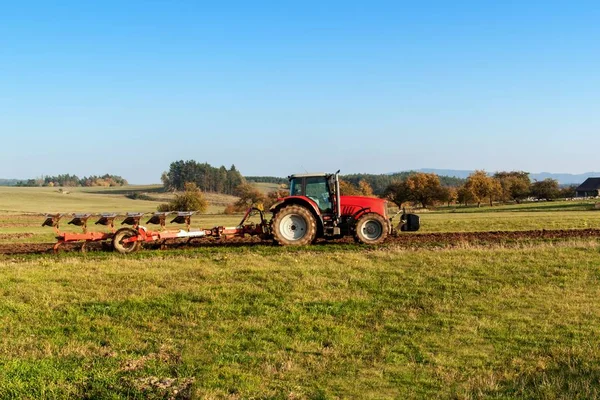 Lapangan tiang traktor merah. Musim gugur lapangan kerja. Kehidupan di peternakan. Lanskap pertanian di Republik Ceko . — Stok Foto