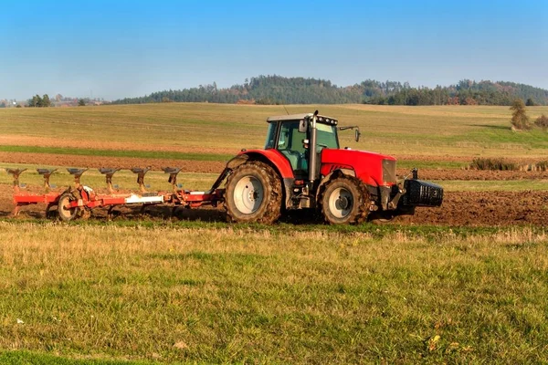 Lapangan tiang traktor merah. Musim gugur lapangan kerja. Kehidupan di peternakan. Lanskap pertanian di Republik Ceko . — Stok Foto