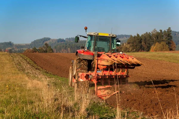 Lapangan tiang traktor merah. Musim gugur lapangan kerja. Kehidupan di peternakan. Lanskap pertanian di Republik Ceko . — Stok Foto