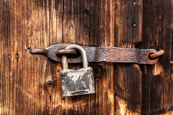 En gammal rostig lås på en trädörr. Skydd mot stöld. Ett säkert hus. — Stockfoto