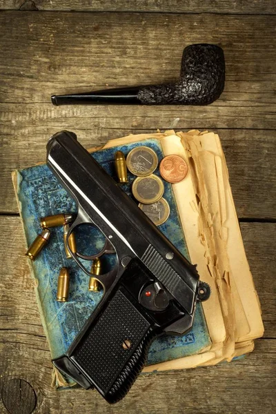 Waffe und altes Buch. Kriminalroman. Holzpfeife. Pistolen und Patronen auf dem Tisch. — Stockfoto