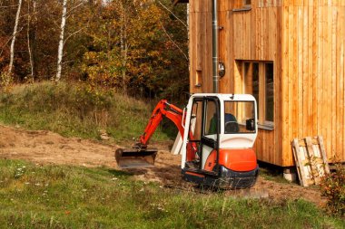 Mini ekskavatör bir inşaat alanı üzerinde. Kazı çalışmaları. Ekskavatör bahçede inşaat.