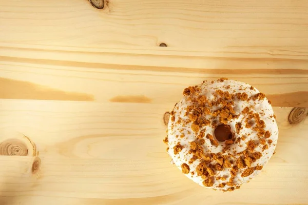 Donut on a wooden table. Unhealthy food. Dangers of obesity. — Stock Photo, Image