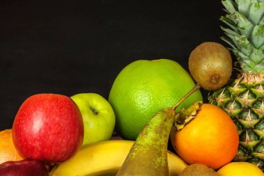 Siyah mutfak masası üzerinde farklı meyve. Gıda sporcular için. Soğuk algınlığı ve grip karşı vitamin.