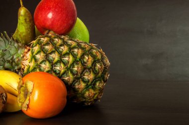 Siyah mutfak masası üzerinde farklı meyve. Gıda sporcular için. Soğuk algınlığı ve grip karşı vitamin.