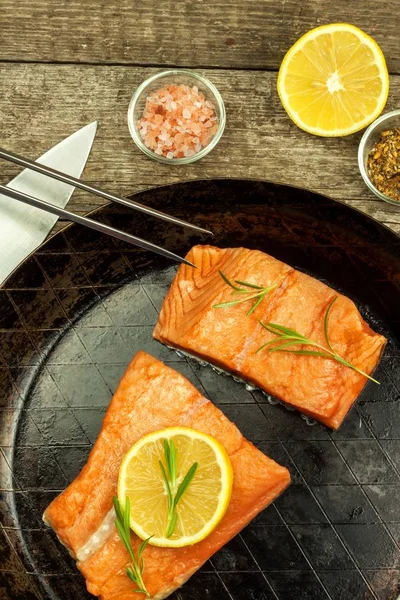 Frozen salmon on the kitchen table. Diet food. Home cooking fish. Steel kitchen pan.