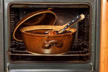 Elektrikli ev fırın ve seramik kap. Et yemekleri pişirme. Fırında gıda hazırlama.