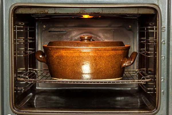 Ηλεκτρικός φούρνος εσωτερικού και κεραμική γλάστρα. Ψήσιμο πιάτα για το κρέας. Προετοιμασία του φαγητού στο φούρνο. — Φωτογραφία Αρχείου