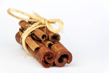 Beyaz bir arka plan üzerinde tarçın adet. Aromatik baharatlar satışı.