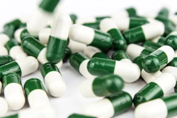 Χάπια πράσινο-λευκό σε λευκό φόντο. Φαρμακευτική βιομηχανία. Ανάπτυξη νέων φαρμάκων. — Φωτογραφία Αρχείου