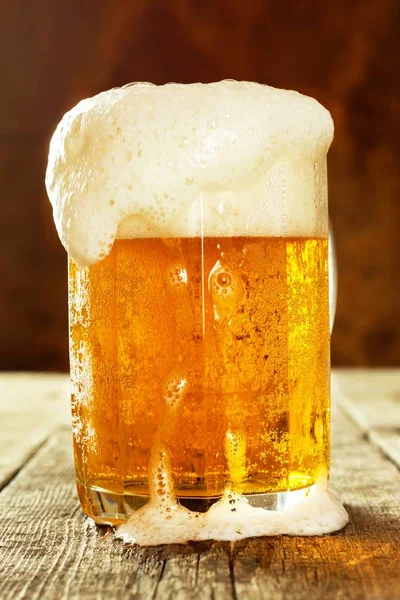 Sklenicí piva na starý dřevěný stůl. Prodej alkoholu. Pivní reklama. — Stock fotografie