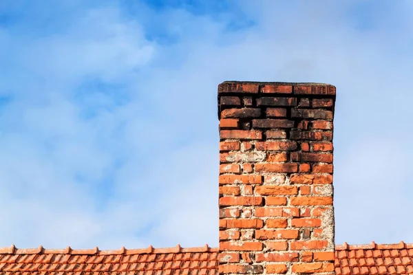 Alter Ziegelkamin. Schornstein mit Himmel im Hintergrund. umweltfreundliche Beheizung eines Einfamilienhauses. — Stockfoto