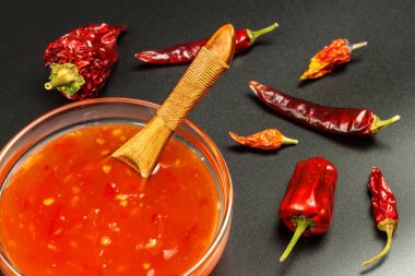 Sos biber ile yaptı. Baharatlı gıda hazırlanması. Sağlıklı gıda. Siyah bir arka plan üzerinde.