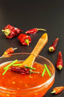 Sos biber ile yaptı. Baharatlı gıda hazırlanması. Sağlıklı gıda. Siyah bir arka plan üzerinde.