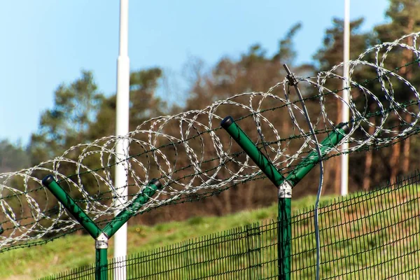 Fence with razor barbed wire. Guarded area. Military base. Razor wire. — Stock Photo, Image