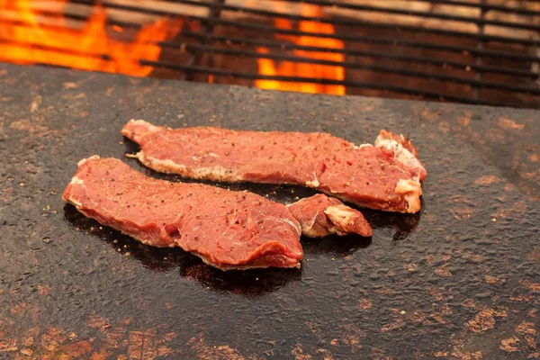 在花岗岩盘子上烤牛排。在室外火灾中准备肉类。夏季烧烤. — 图库照片
