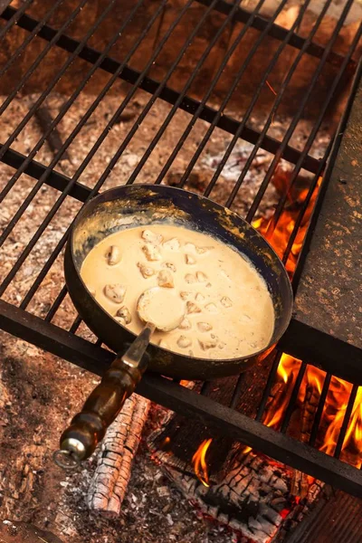 Εμαγιέ ταψί στη φωτιά. Προετοιμασία των μανιταριών μπριζόλα σάλτσα. Φωτιά στο στρατόπεδο. — Φωτογραφία Αρχείου