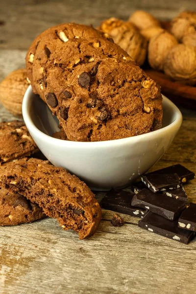 Biscuits au chocolat faits maison avec des noix sur une table en bois. Nourriture sucrée pour le café. Nourriture malsaine. Risque d'obésité . — Photo