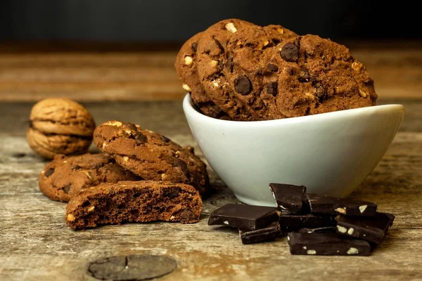 Biscuits au chocolat faits maison avec des noix sur une table en bois. Nourriture sucrée pour le café. Nourriture malsaine. Risque d'obésité . — Photo