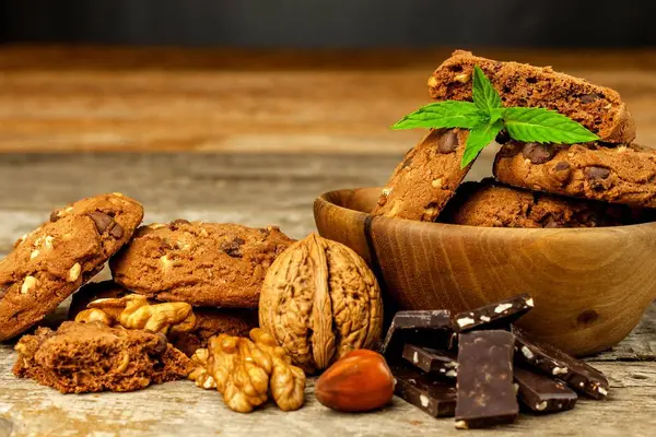 Zelfgemaakte chocoladekoekjes met noten op houten tafel. Lekker eten voor koffie. Ongezond voedsel. Risico op obesitas. — Stockfoto