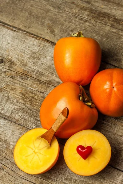 成熟的橙子，西门子果，木桌上的木瓜，西门子片，一组木瓜。 日本秋季Kaki Persimmon (Diospyros kaki)水果 — 图库照片