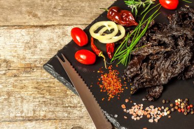 Mutfak masasında kurutulmuş et. Ev yapımı kurutulmuş sığır eti. Acı biberle marine edilmiş et. Diyet yemek. Dayanıklı yemek. Sporcular için proteinler.