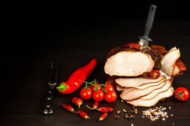 Mutfak tahtasında tütsülenmiş et. Ev yapımı füme domuz eti ve sebze. Sağlıksız yiyecekler. Et işleme. Hassas bir lezzet..