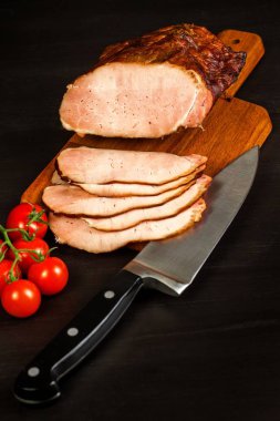 Mutfak tahtasında tütsülenmiş et. Ev yapımı füme domuz eti ve sebze. Sağlıksız yiyecekler. Et işleme. Hassas bir lezzet..