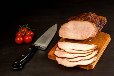 Mutfak tahtasında tütsülenmiş et. Ev yapımı füme domuz eti ve sebze. Sağlıksız yiyecekler. Et işleme. Hassas bir lezzet..