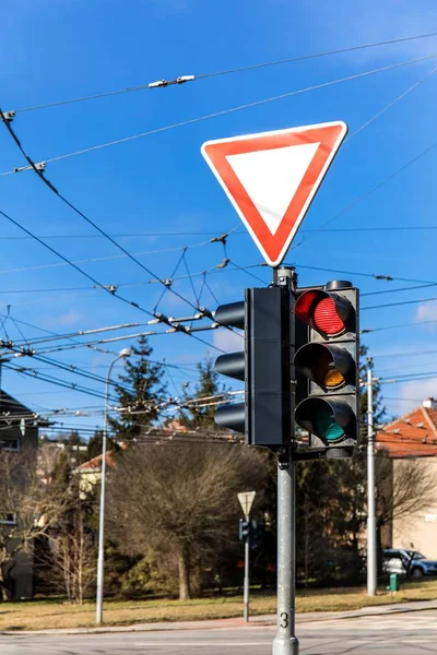 Semáforo en la intersección de la ciudad. Línea de energía para trolebús. Detenga la señal luminosa. La señal de tráfico cede. Ciudad de Brno República Checa . — Foto de Stock