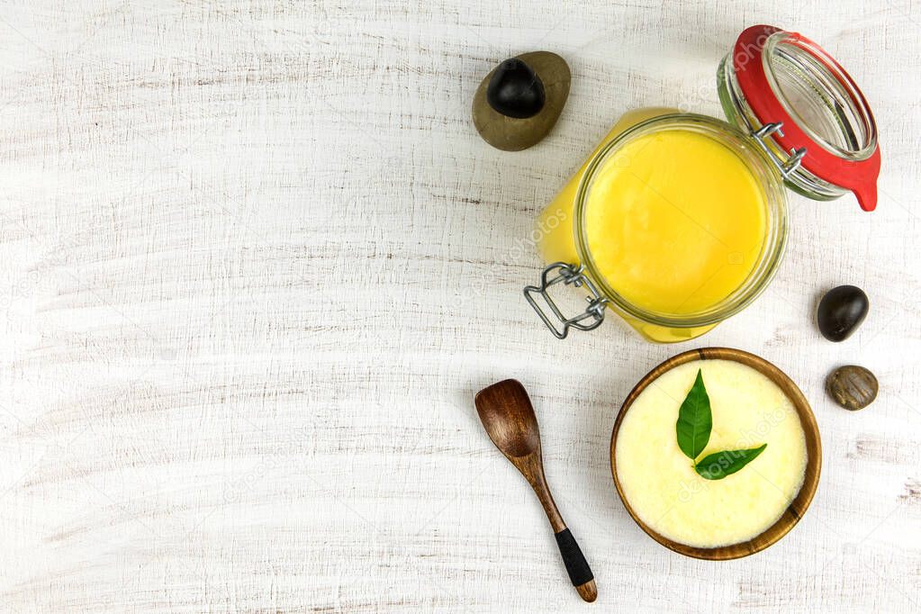 Ghee or clarified butter in jar. Healthy eating and using organic fresh made products. Healthy ingredient for cooking organic meal.Spoon with ghee butter