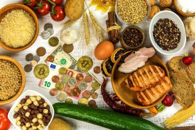 Para ve yemek beyaz bir masada. Yiyeceğin fiyatı. Artan gıda fiyatları kavramı. Pahalı sebzeler.