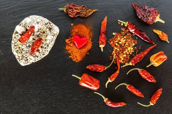 Chilli, red pepper flakes and chilli powder on slate. Spicy food. Hot spices.