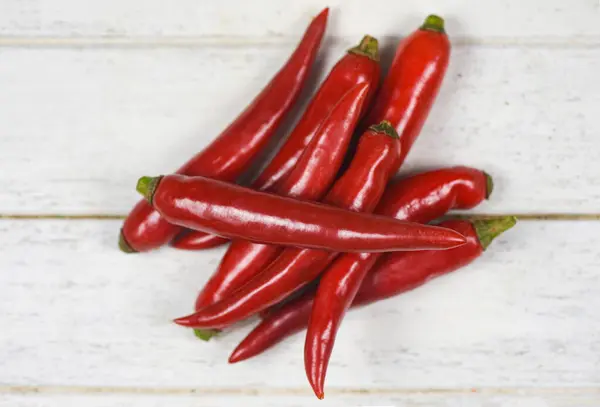Röd chili peppar på en vit trä bakgrund / färsk chili varm — Stockfoto