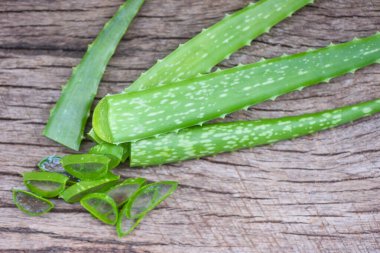 Aloe vera bitkisinin rustik ahşap arka plandaki dilimi - yakın plan