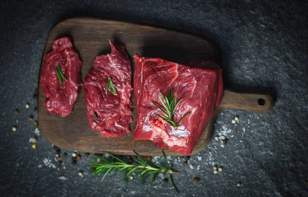 Carne fresca en rodajas sobre fondo negro - Filete crudo de res con —  Fotos de Stock