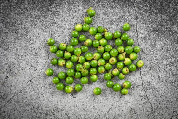 Granos de pimienta en el fondo de la placa oscura semilla de pimienta verde fresca — Foto de Stock