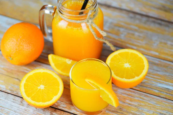 Jus d'orange dans le bocal en verre et tranche d'orange fraîche sur wo — Photo