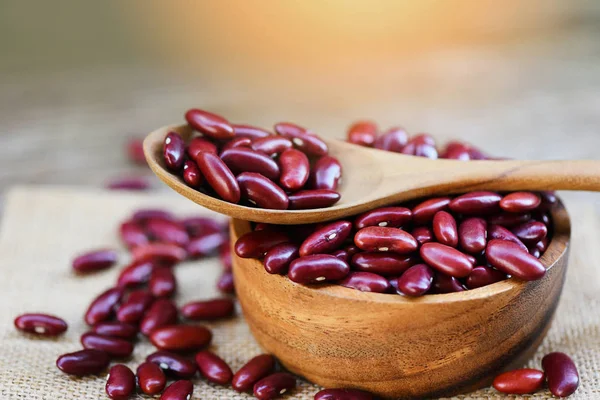 Red bean in wooden bowl and spoon on sack background - Grains re — Stock Photo, Image