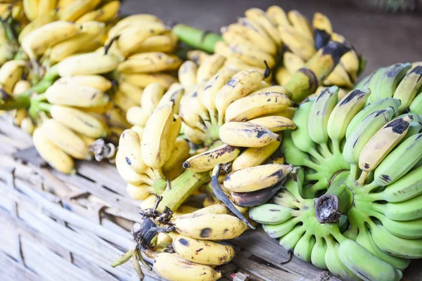 Čerstvé zralé banán žluté a zelené banány na pozadí dřeva v — Stock fotografie
