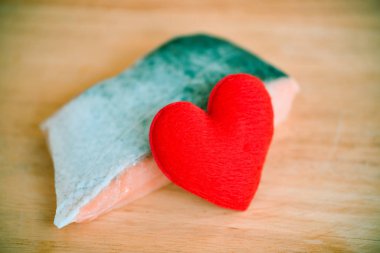 Taze çiğ somon balığıyla ahşap üzerinde kalbi olan düğün yemeği.