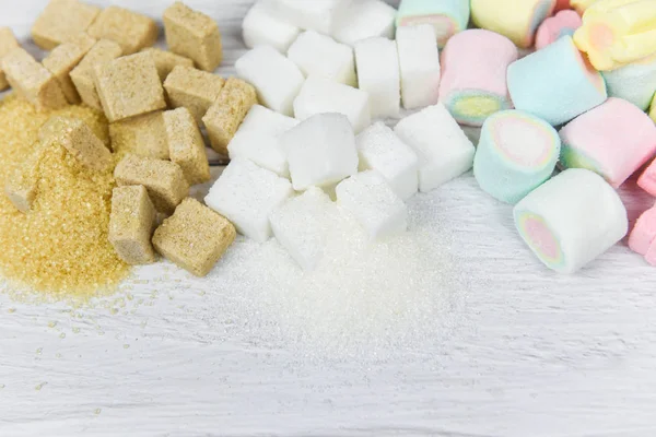 Açúcar mascavo, açúcar branco, cubos de açúcar e doces coloridos — Fotografia de Stock