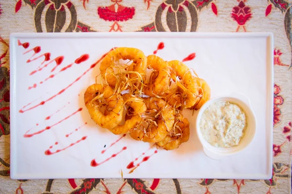 Anillos de calamar fritos en plato blanco con salsa, vista superior - restaur — Foto de Stock