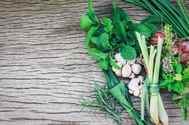 Kaba ahşap arka planda doğal taze otlar ve baharat.