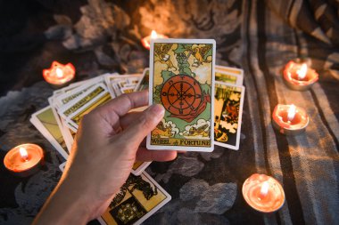 Karanlığın sırtında mum ışığı olan tarot kartı.
